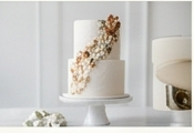 Elegant white tiered wedding cake with gold floral detailing